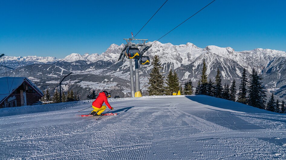 Skifahrer mit Planai-Hauptgondel und Dachsteinpanorama | © Christine Höflehner