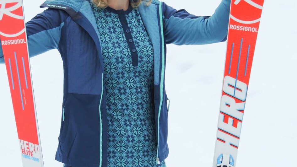 Skifahrerin im blau-gemustertem Skianzug.